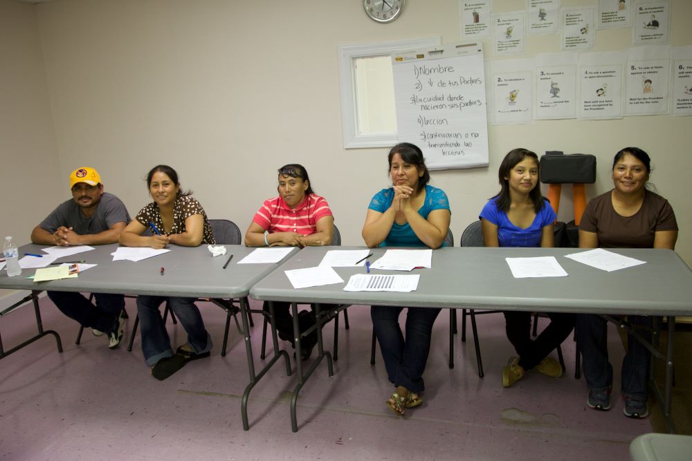 Un grupo de personas sentadas en una mesa.