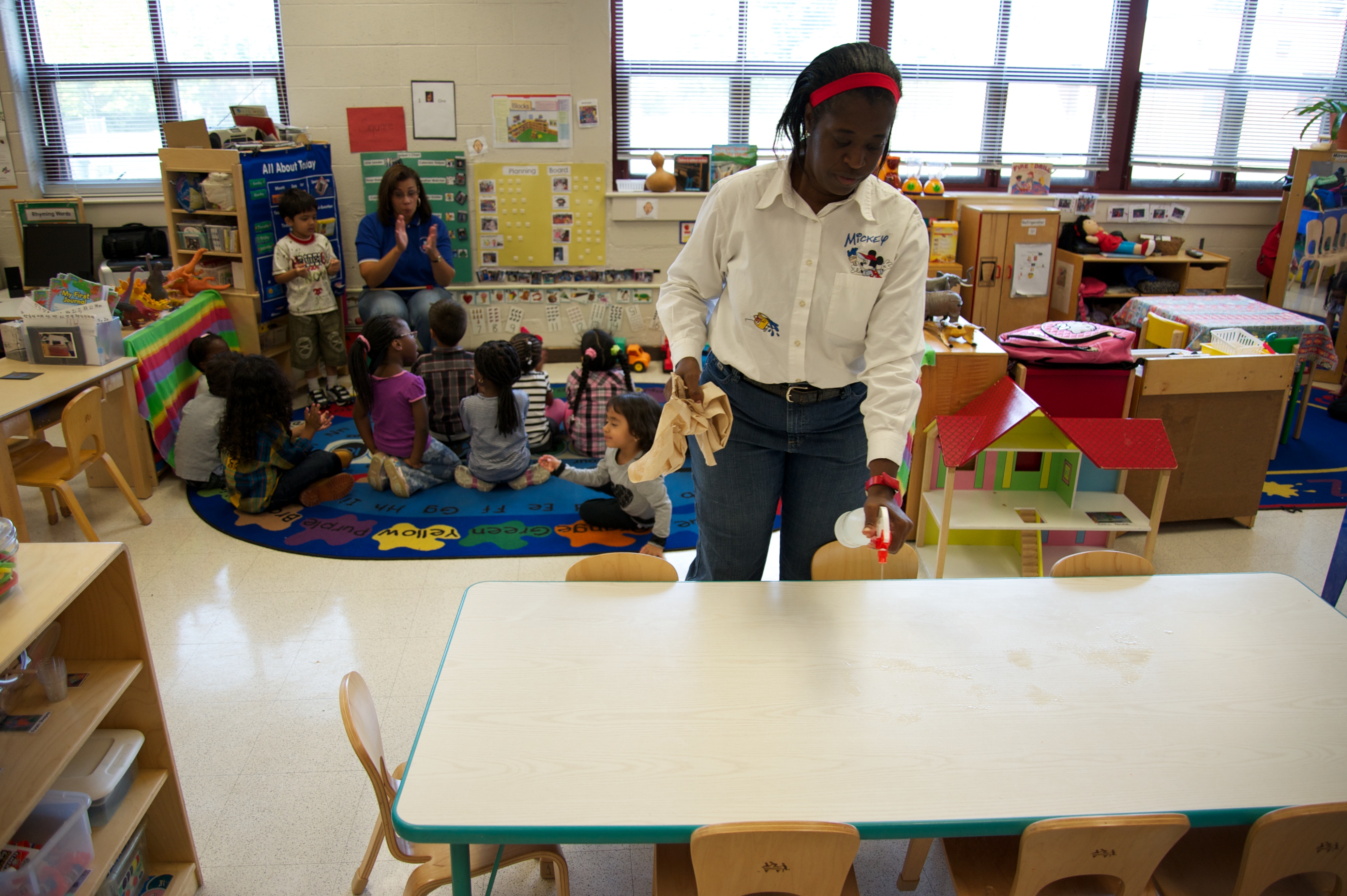 Staff member cleaning tables and chairs.