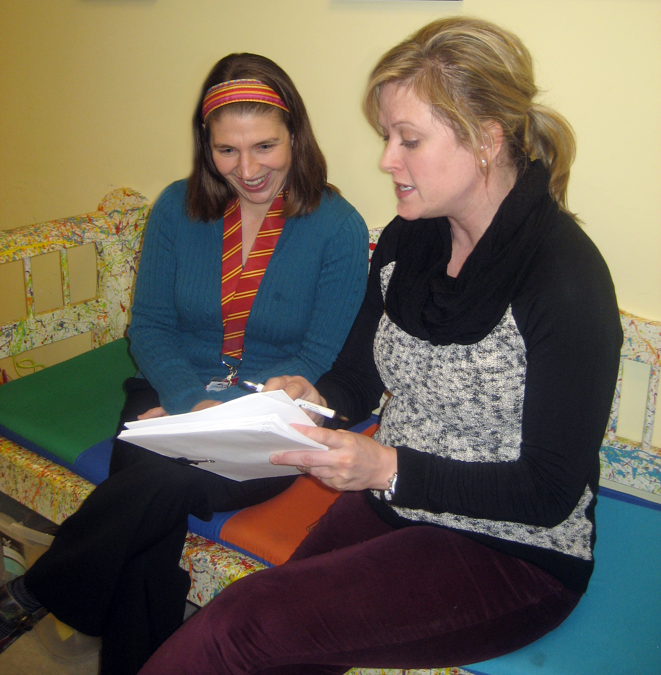 Two women reviewing notes.