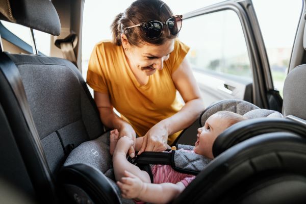 Woman securing a child in the car seat