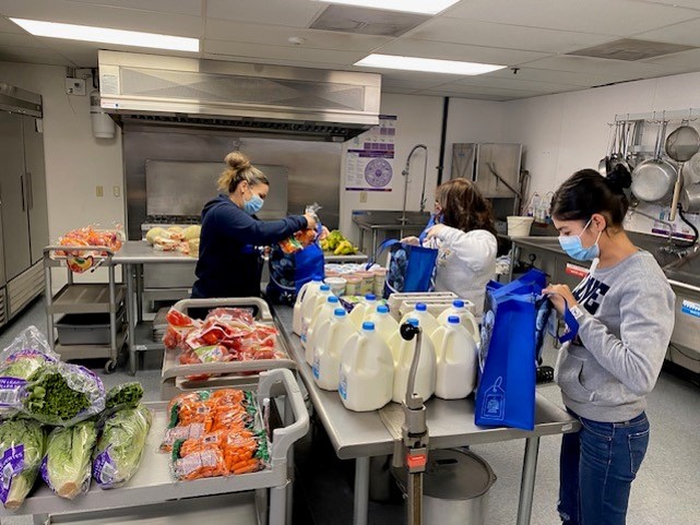 Personal que ensambla bolsas de comida para su entrega