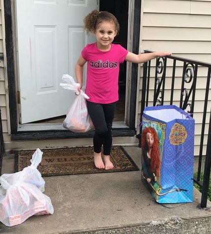 Child receiving a grocery bag.