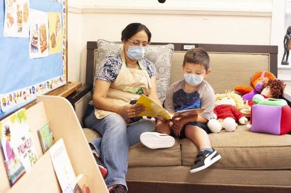 Maestra leyéndoles un cuento a niños en un salón de clase