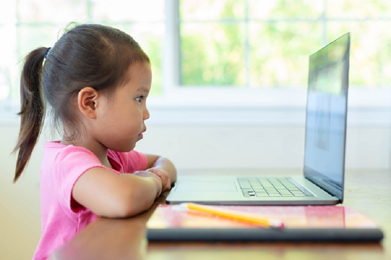 Niña en edad preescolar asistiendo a un aula virtual