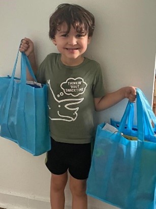 Niño con dos bolsas en las manos.