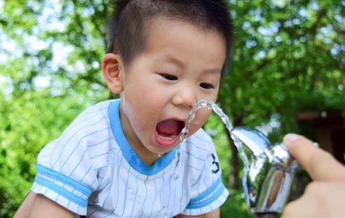 Child drinking from water fountain.