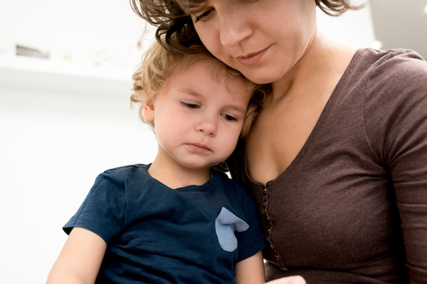 Madre sosteniendo y consolando a un niño.