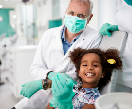 Niña sentada en la silla del dentista para que le examinen los dientes.