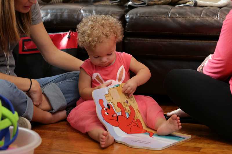 Bebé jugando con un libro para niños.