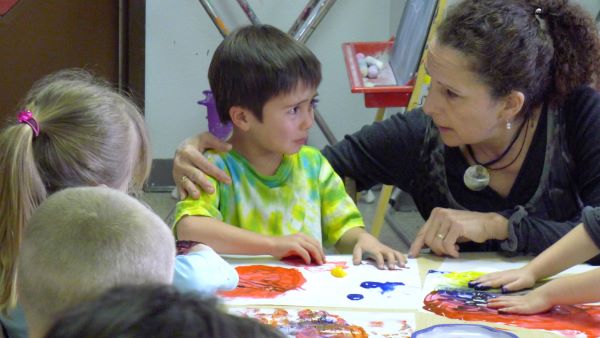 Una maestra tranquilizando a un niño disgustado.