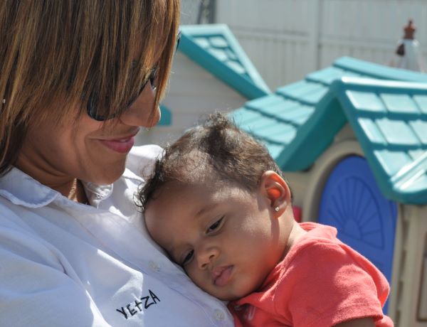 Staff member holding a sleeping infant.