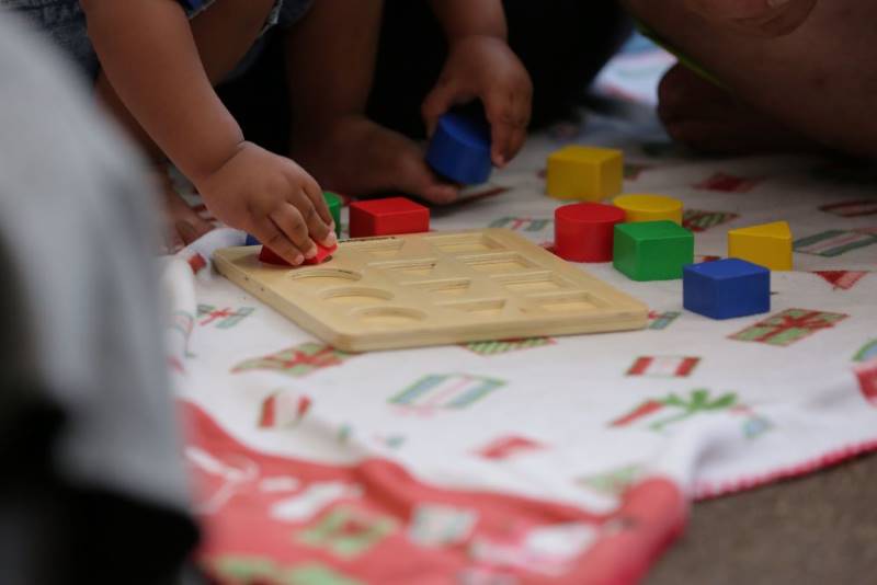 Primer plano de la mano de un niño con bloques de colores intensos.