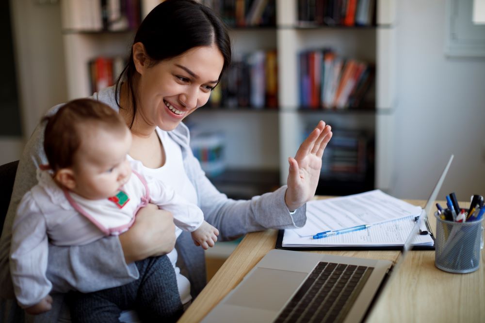 Mother and child waving at participants on a virtual video call.