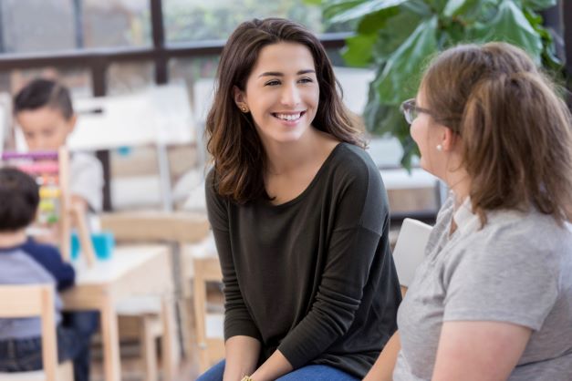 Dos mujeres sonrientes hablando.