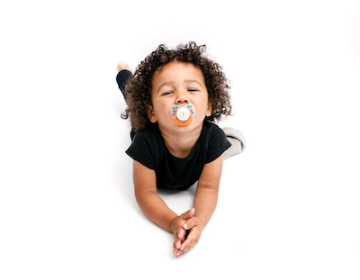 An older child with a pacifier in their mouth.