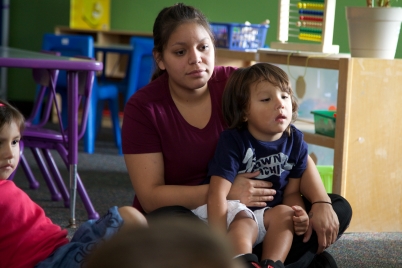 Teacher with small boy on her lap.