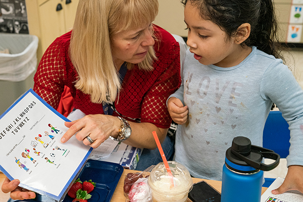 Teacher talking with a child about an upcoming activity.