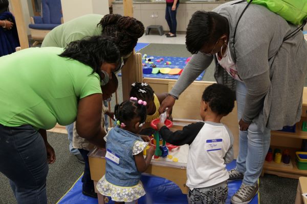 Adults helping children pick out toys.