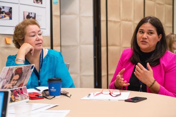 Dos mujeres hablando en una mesa.