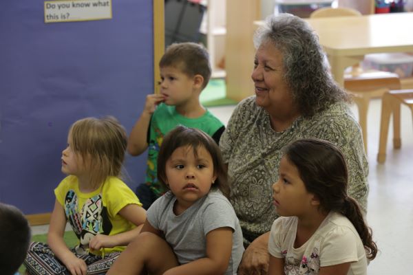 Personal de la guardería sentado con los niños.