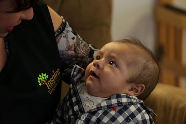 Un primer plano de un bebé en brazos de su madre.