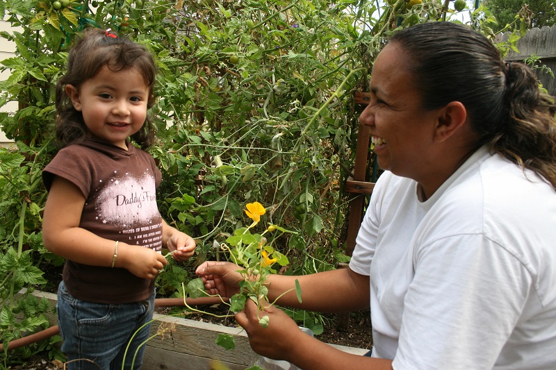 Madre e hija recogiendo flores.