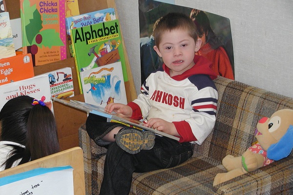 Young boy sitting in a child-sized sofa.