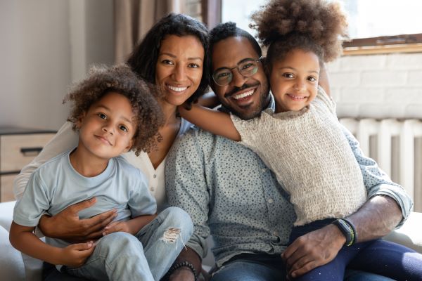 Mother and father posing with their two young daughters.