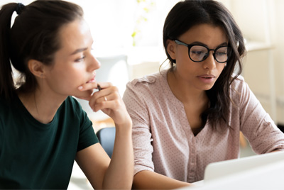 Dos mujeres mirando la pantalla de una computadora