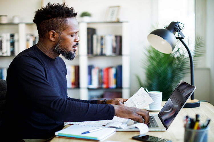 Man working on a laptop at his desk.