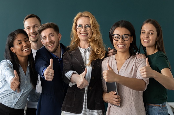 Miembros del personal sonrientes y con el pulgar hacia arriba.