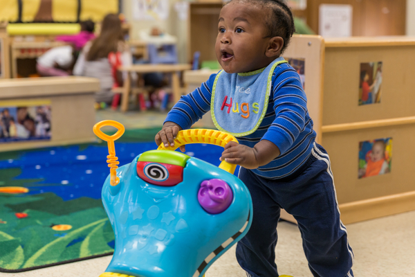 Young boy using a colorful walker.