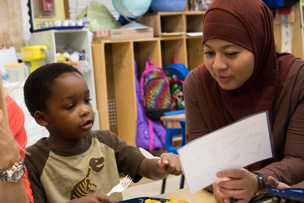 Teacher and child looking at a piece of paper.