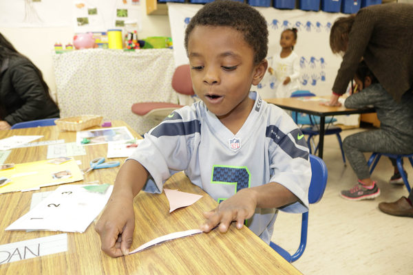 Young boy cutting strips of paper.