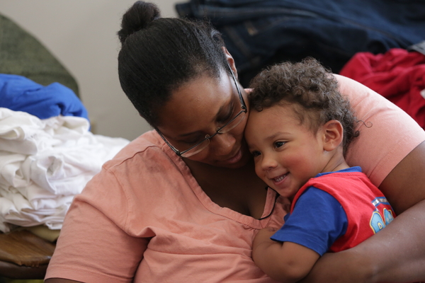 Teacher hugging young boy.