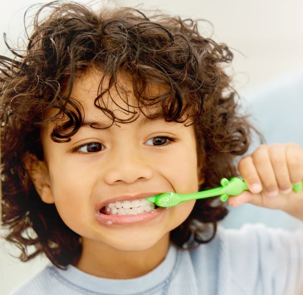 Child happily brushing their teeth.