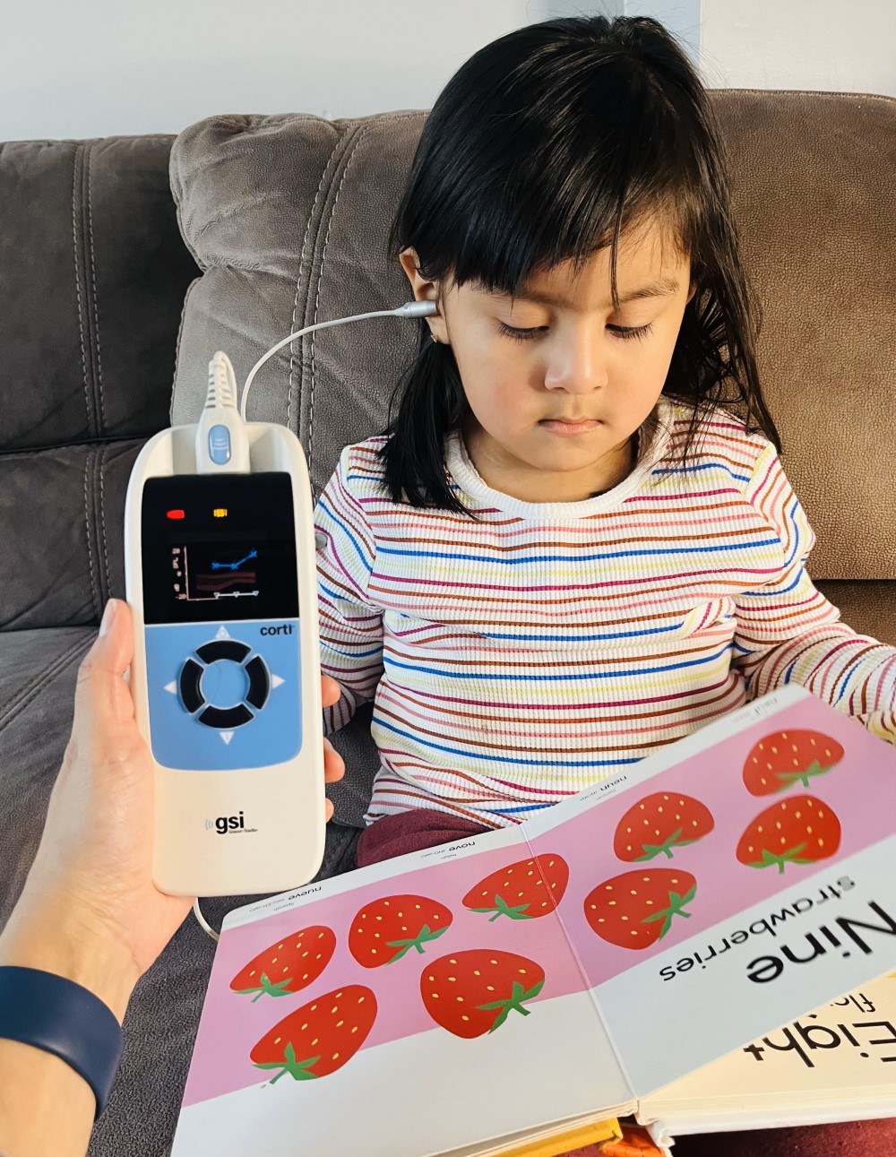 Child being administered an OAE hearing test.