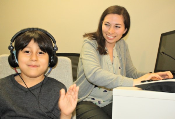 Niño a quien se le está administrando una prueba de audición puretone.