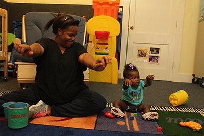 Teacher and child stretching arms out in front of them.