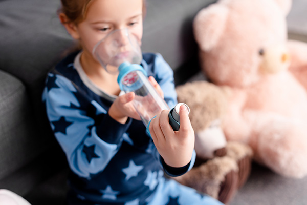 Child breathing through a respiratory medication.