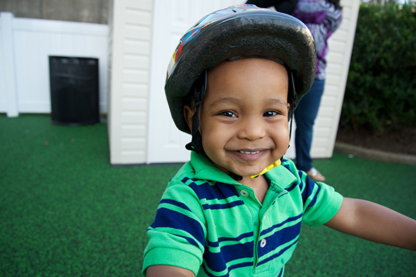 Child using a helmet while playing outdoors.