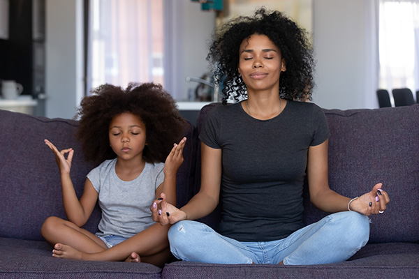 Woman and child practicing meditation.