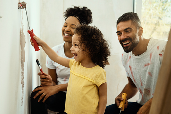 Family painting a wall together.