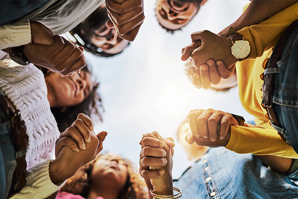 Grupo de adultos en ronda tomándose de la mano.