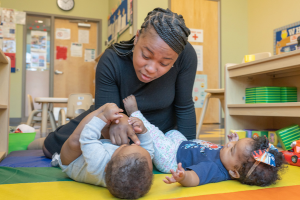 Teacher interacting with two toddlers.