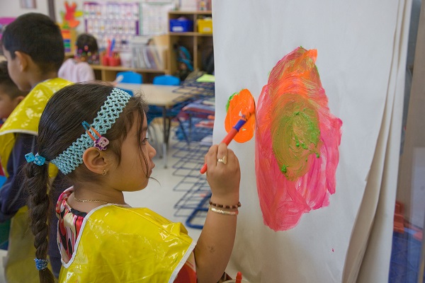 Girl painting on a paper flip-board.