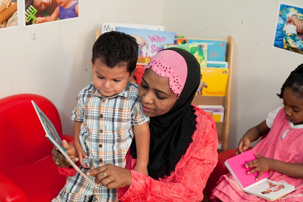 Teacher showing a story book to a child.