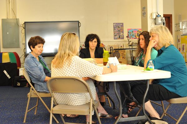 A group of women sitting at a table having a meeting.