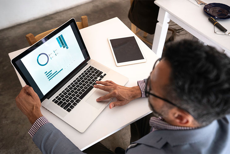 Un hombre mirando un gráfico en su laptop