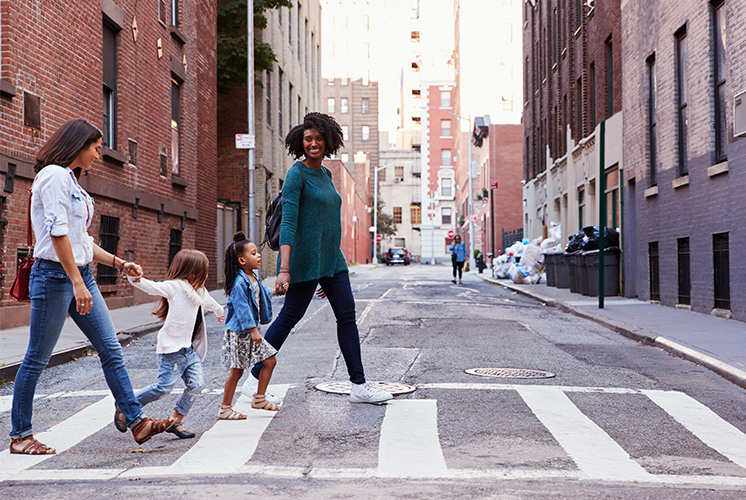 Family crossing a street in the city.